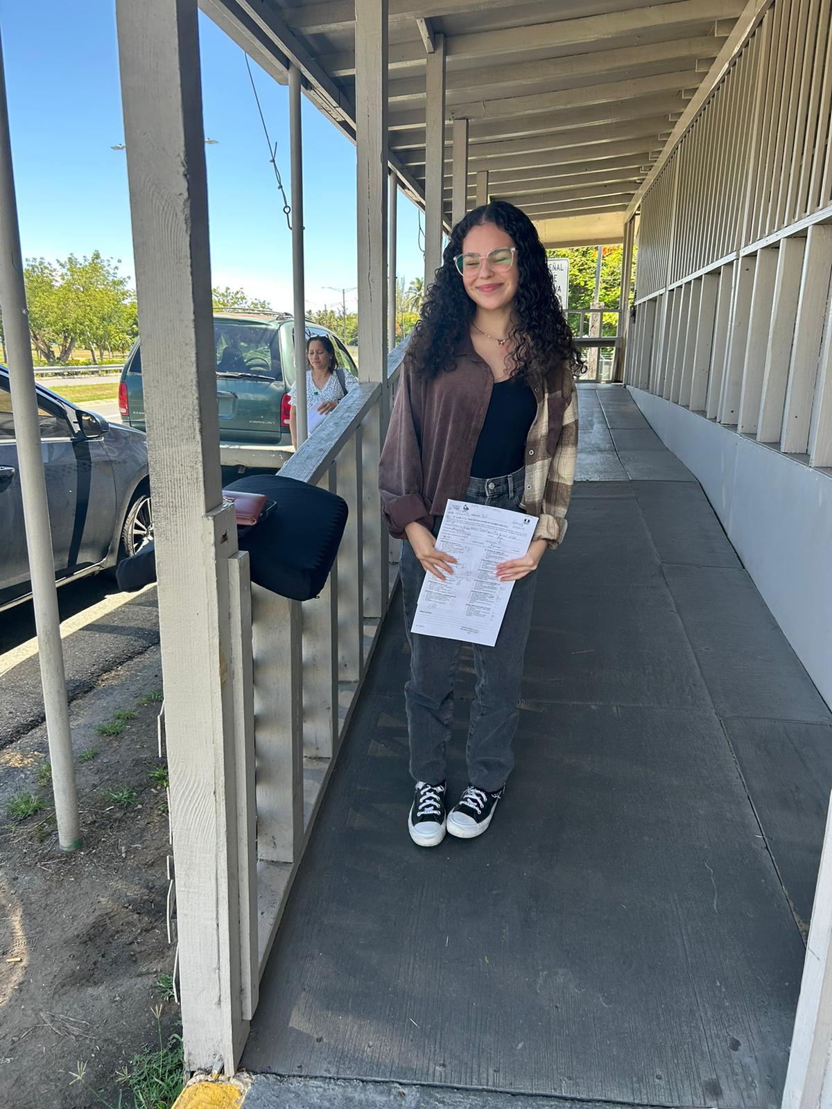 Estudiante con su hoja de examen aprobado